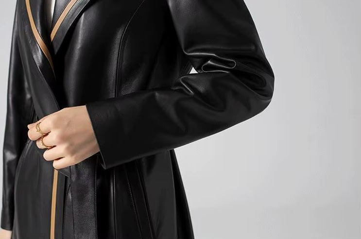 Women's Structured Leather Coat in Onyx with Warm Ochre Trim. Close-up of the midsection, showcasing the A-line silhouette and seamless button closure. Borcelleclothes.