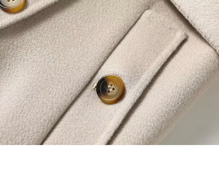 Detail of the diagonally exposed single-welt pocket on the Pearl Bush structured wool coat. From Borcelleclothes.