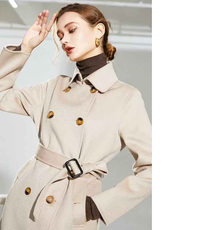Model lightly touching her hair while wearing the Pearl Bush structured wool coat. From Borcelleclothes.