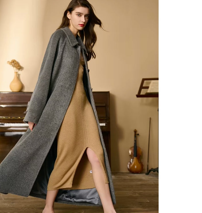 Model walking in profile in the Flint version of the Suri alpaca wool coat. From Borcelleclothes.