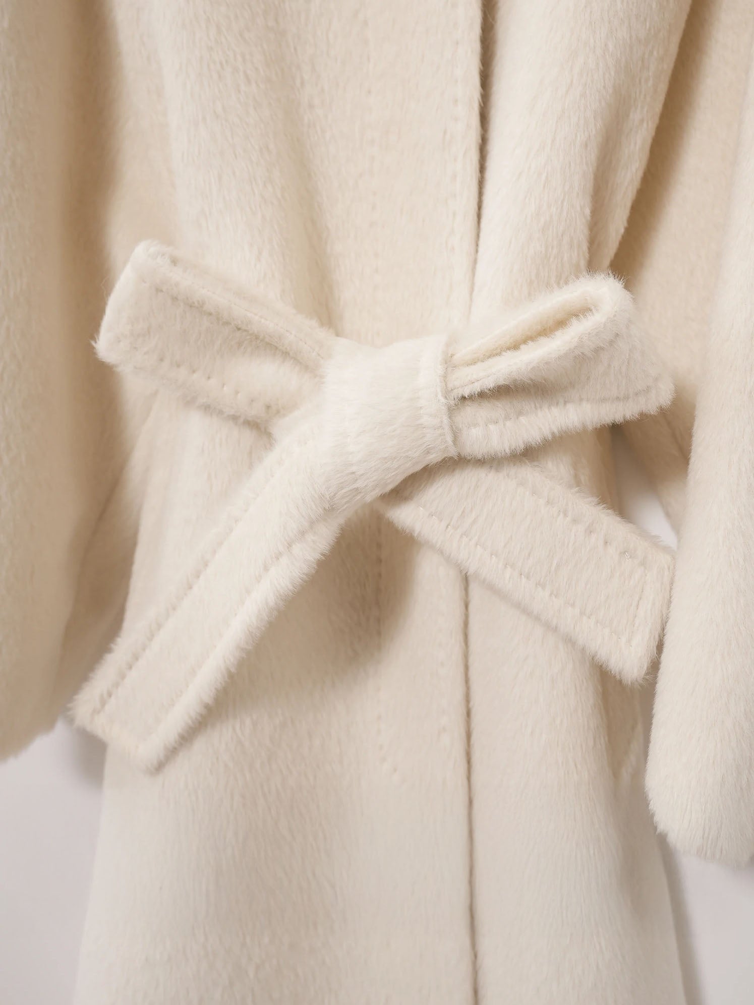 Adjustable waist belt of the Pearl Bush Suri alpaca wool coat tied in a bow. From Borcelleclothes.