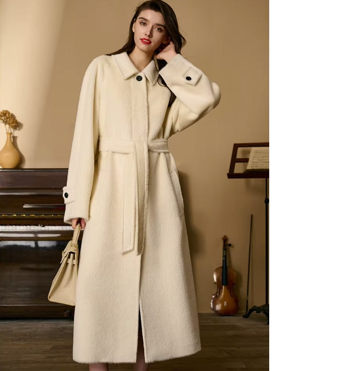 Model adjusting her hair while wearing the Pearl Bush Suri alpaca wool coat. From Borcelleclothes.