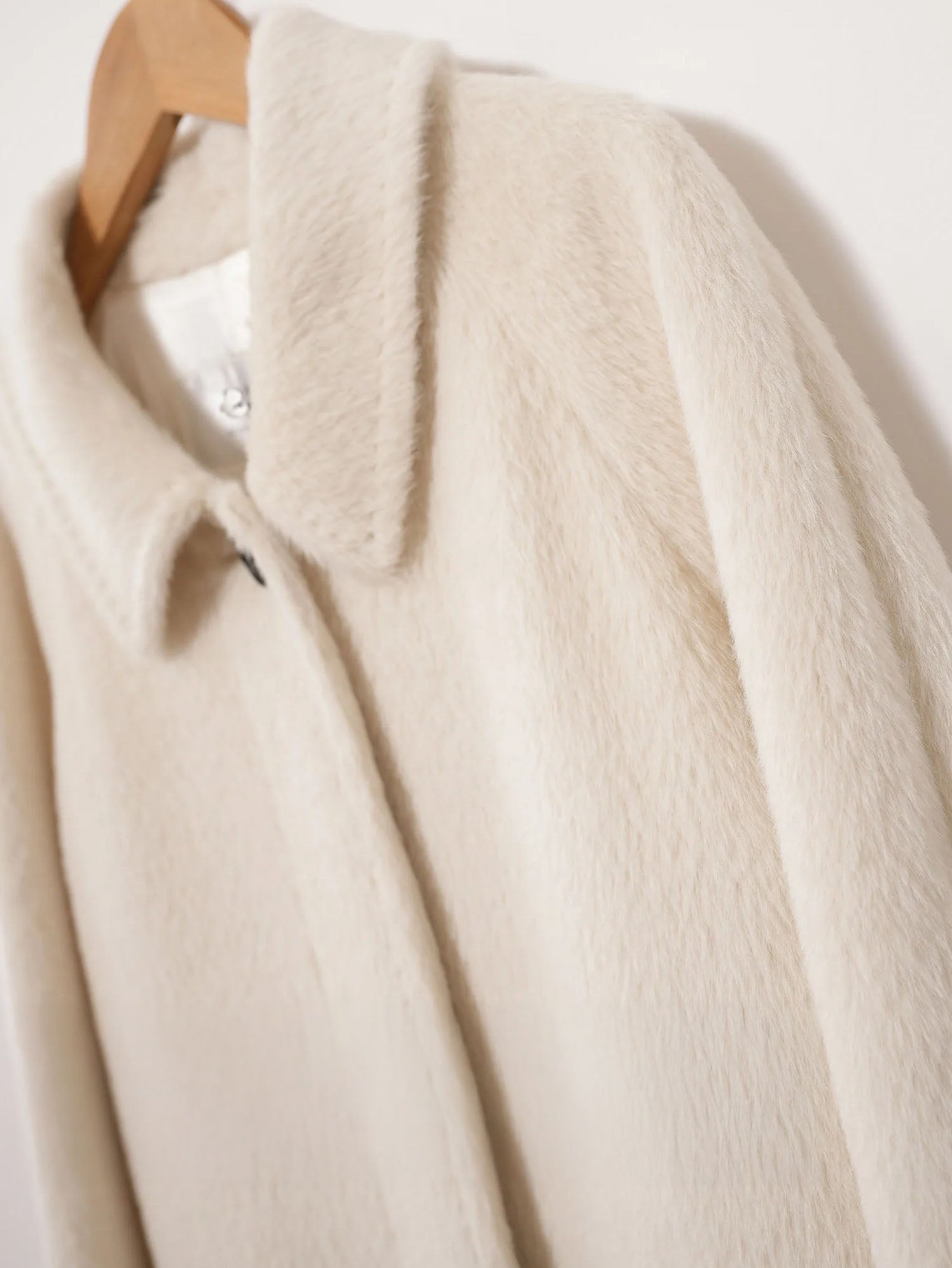 Upper part of the Pearl Bush Suri alpaca wool coat showing the concealed placket and decorative button. From Borcelleclothes.