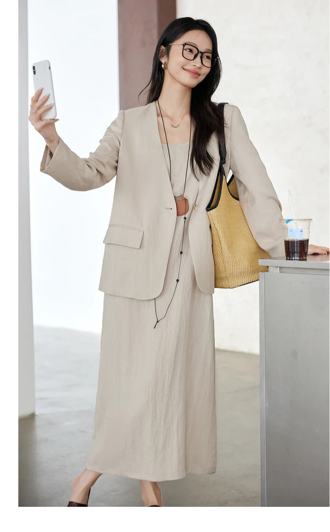 Woman holding a phone while dressed in Swiss Coffee set — poised, composed, and gently structured. From Borcelleclothes.