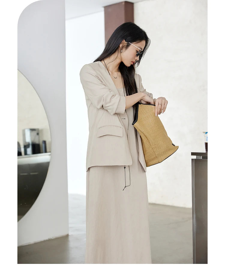 Woman reaching into her bag while wearing Swiss Coffee set — a quiet, composed look in soft neutral tones. From Borcelleclothes.