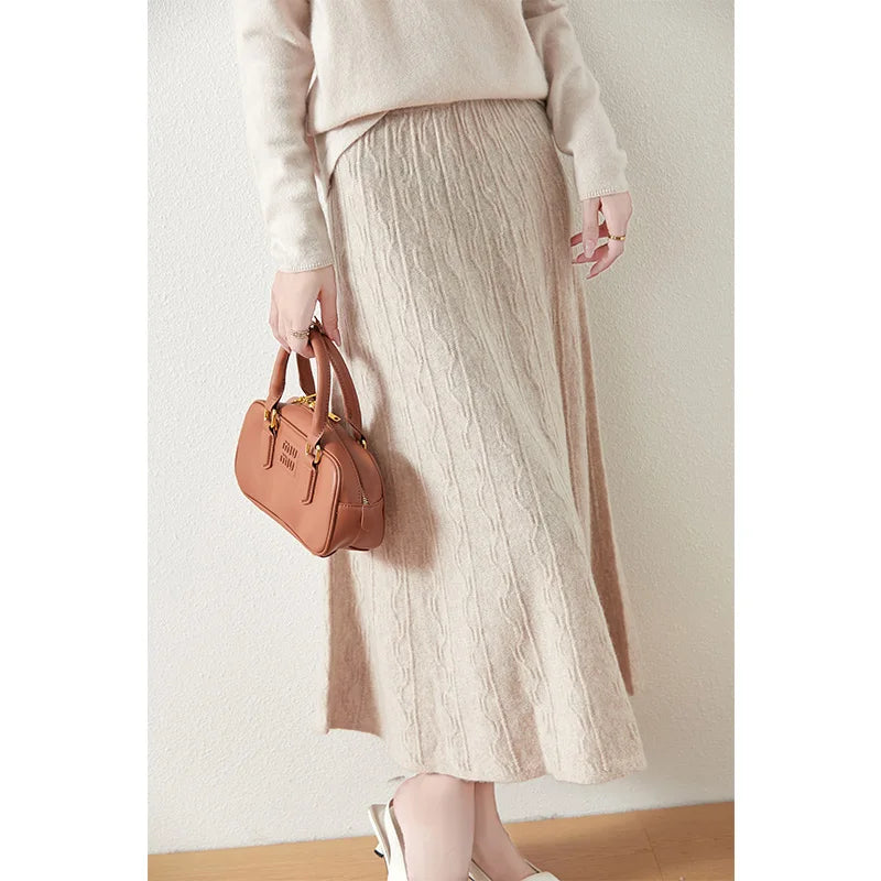 Textured merino wool skirt in Pale Silver, model holding bag, showing full silhouette with soft vertical and wave knit — From Borcelleclothes.