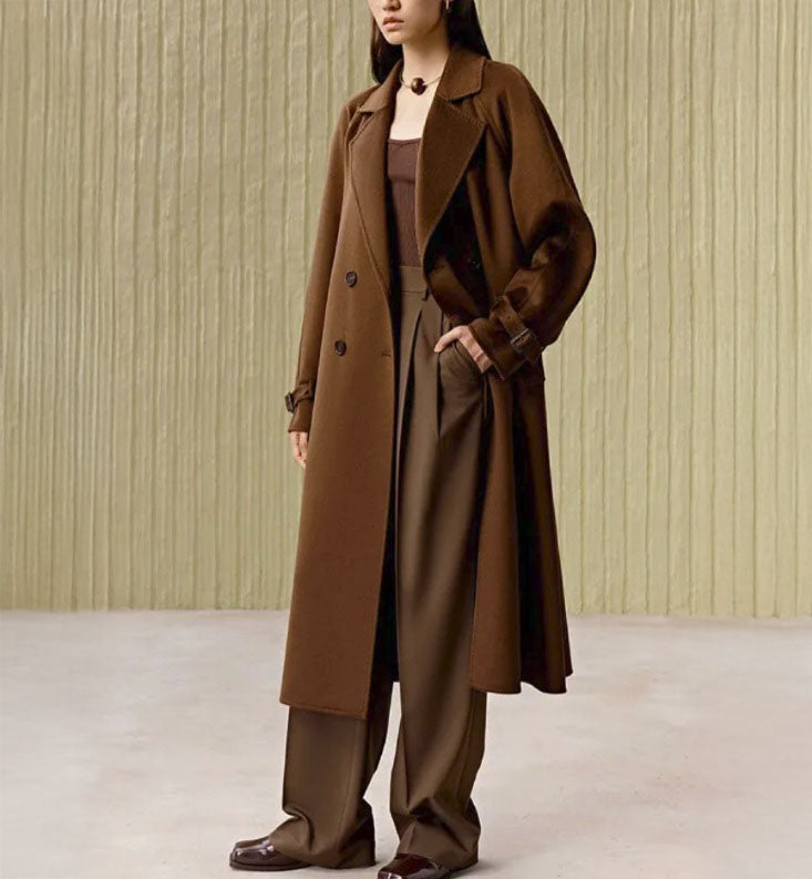 Women's Tibetan Cashmere Coat in Baker's Chocolate, crafted from 100% double-sided Tibetan cashmere, featuring notched lapels, raglan sleeves, adjustable sleeve belts, a waist belt, and diagonally exposed single-welt pockets for a refined and luxurious look. From Borcelleclothes.