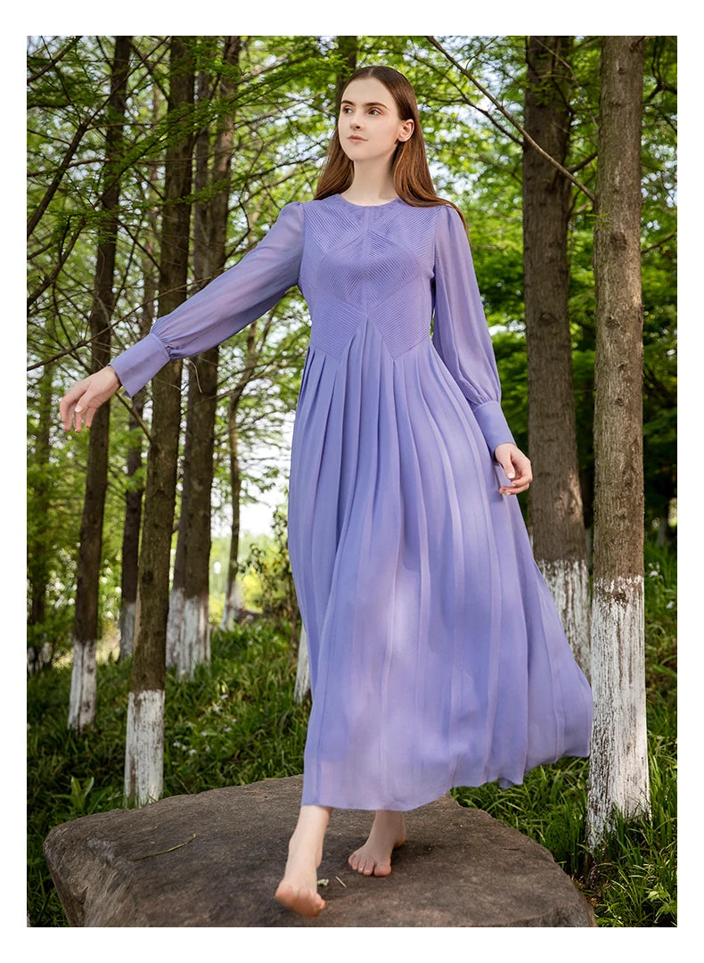 Model walks through a forest in the Cold Purple silk georgette dress, hem slightly lifted by motion, surrounded by dappled light and quiet. From Borcelleclothes.