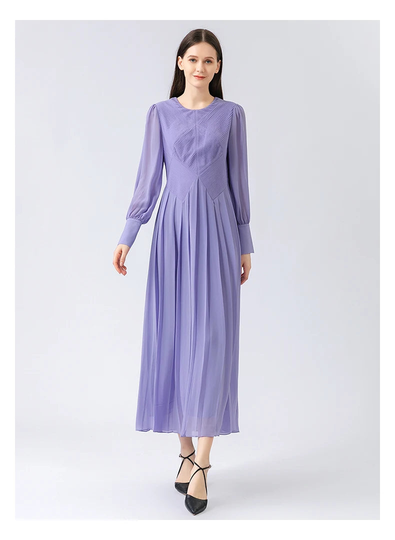 Model walks forward with measured grace, the dress’s architectural top softening into fluid pleats in Cold Purple. From Borcelleclothes.