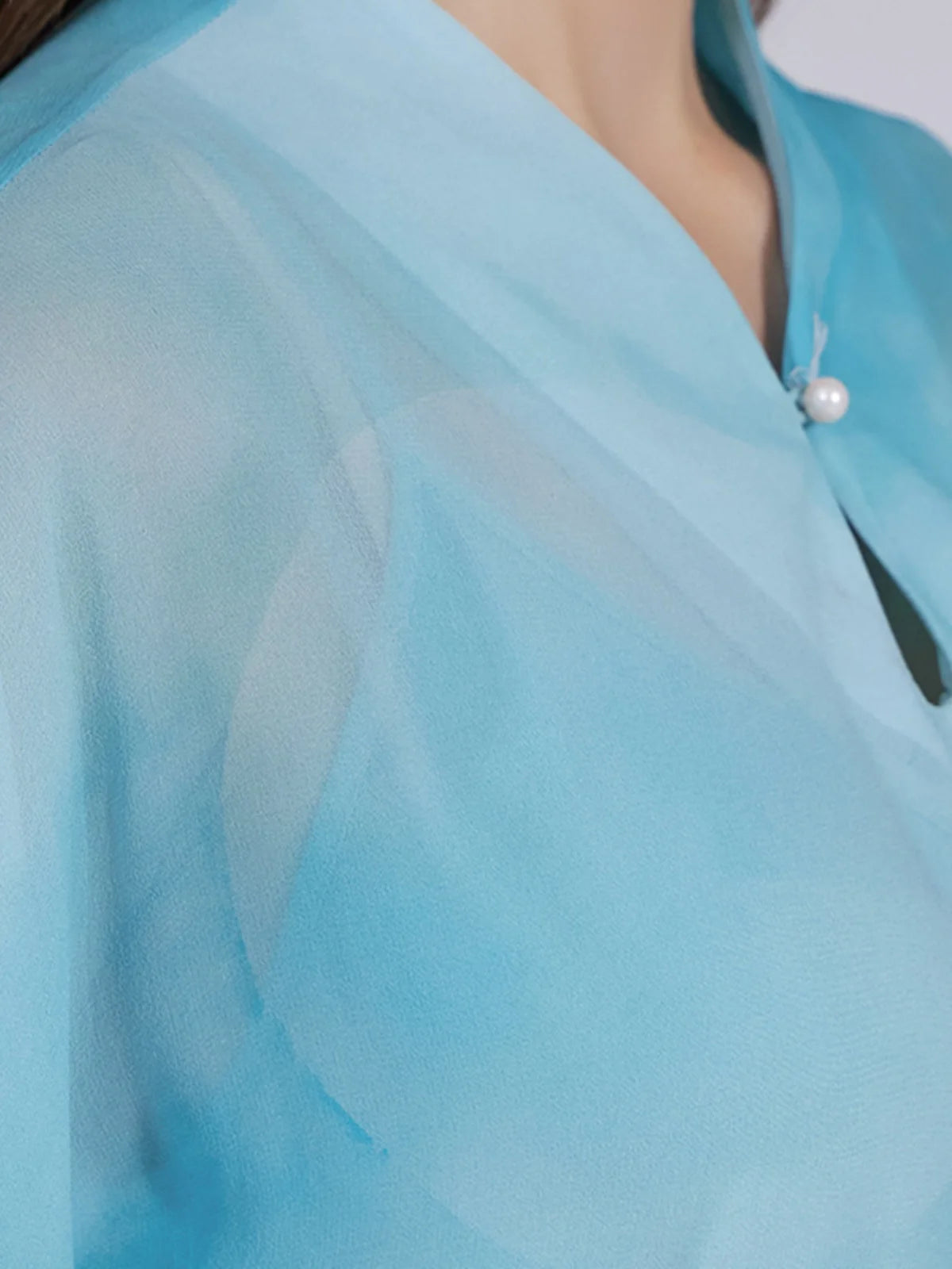 Front upper part of the ensemble, revealing the teardrop neckline and collar detail in Glacier-colored silk. From Borcelleclothes.