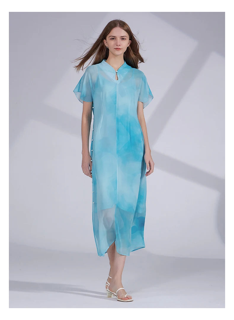 Model stepping forward in the Glacier-colored silk ensemble, capturing motion and layered construction. From Borcelleclothes.