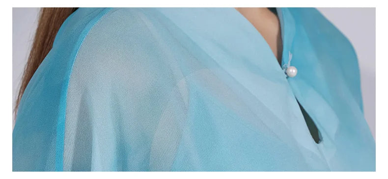 Close-up of the shoulder area in Glacier silk, showing fine tailoring and light chiffon transparency. From Borcelleclothes.