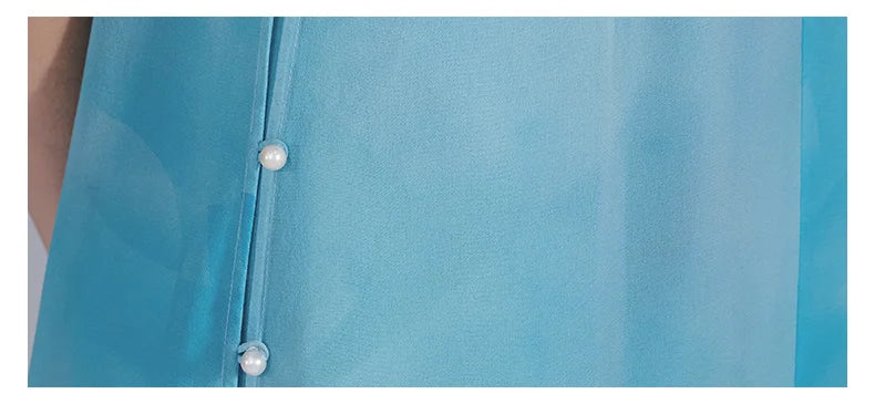 Detailed view of the slit section on the side of the ensemble, showing pearl-like buttons and silk craftsmanship. From Borcelleclothes.