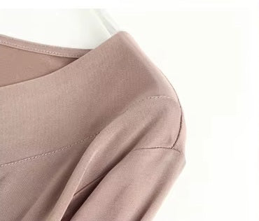 Detailed stitching and textured fabric on the shoulder of a Women's Vintage-Inspired Silk Top in Rose Fog, featuring a V-neckline with delicate pleats and long sleeves in a Mulberry Silk blend. From Borcelleclothes.