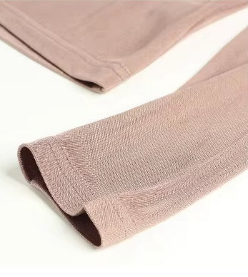 Detailed double-stitching and textured fabric on the sleeve's end of a Women's Vintage-Inspired Silk Top in Rose Fog, featuring a V-neckline with delicate pleats and long sleeves in a Mulberry Silk blend. From Borcelleclothes.