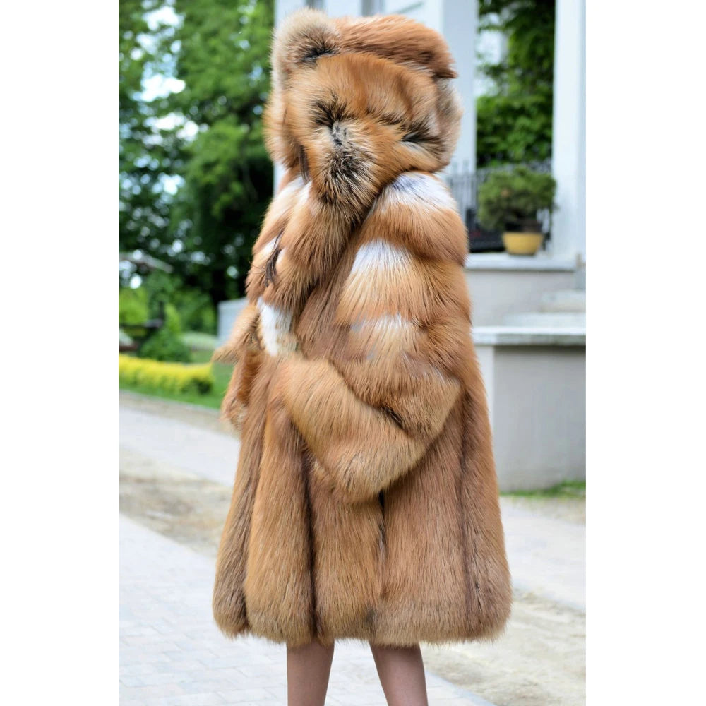 A side view of a woman showcasing the lifted expanded hood of a whiskey silver fox fur coat, emphasizing its enveloping warmth and untamed elegance. From Borcelleclothes.