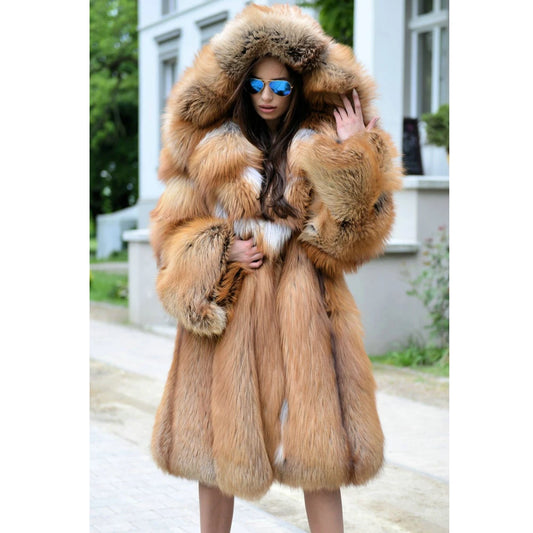 A luxurious mid-calf length whiskey silver fox fur coat with an expanded hood, capturing golden hues that glow like autumn light. The coat exudes untamed elegance and quiet magnetism, embodying effortless confidence. From Borcelleclothes.