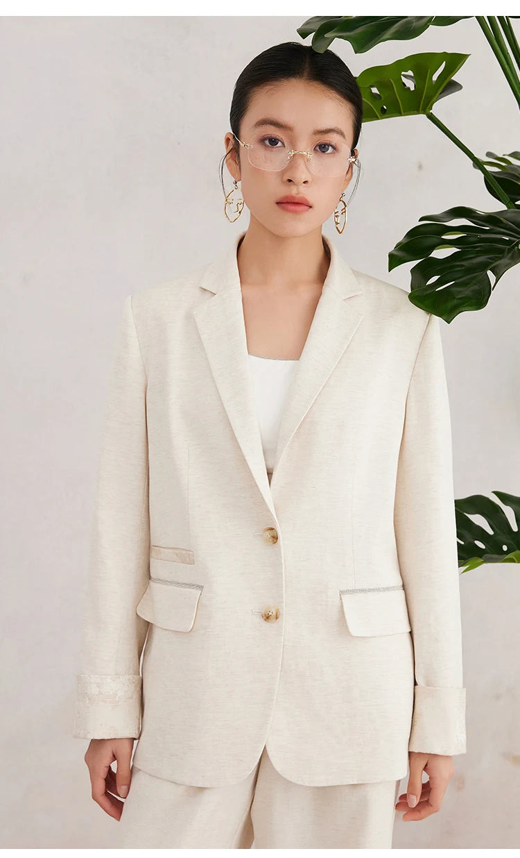 Women’s White Coffee blazer worn with arms relaxed along the sides — showing the clean silhouette, straight lapels, and subtle jacquard cuff detail. From Borcelleclothes.