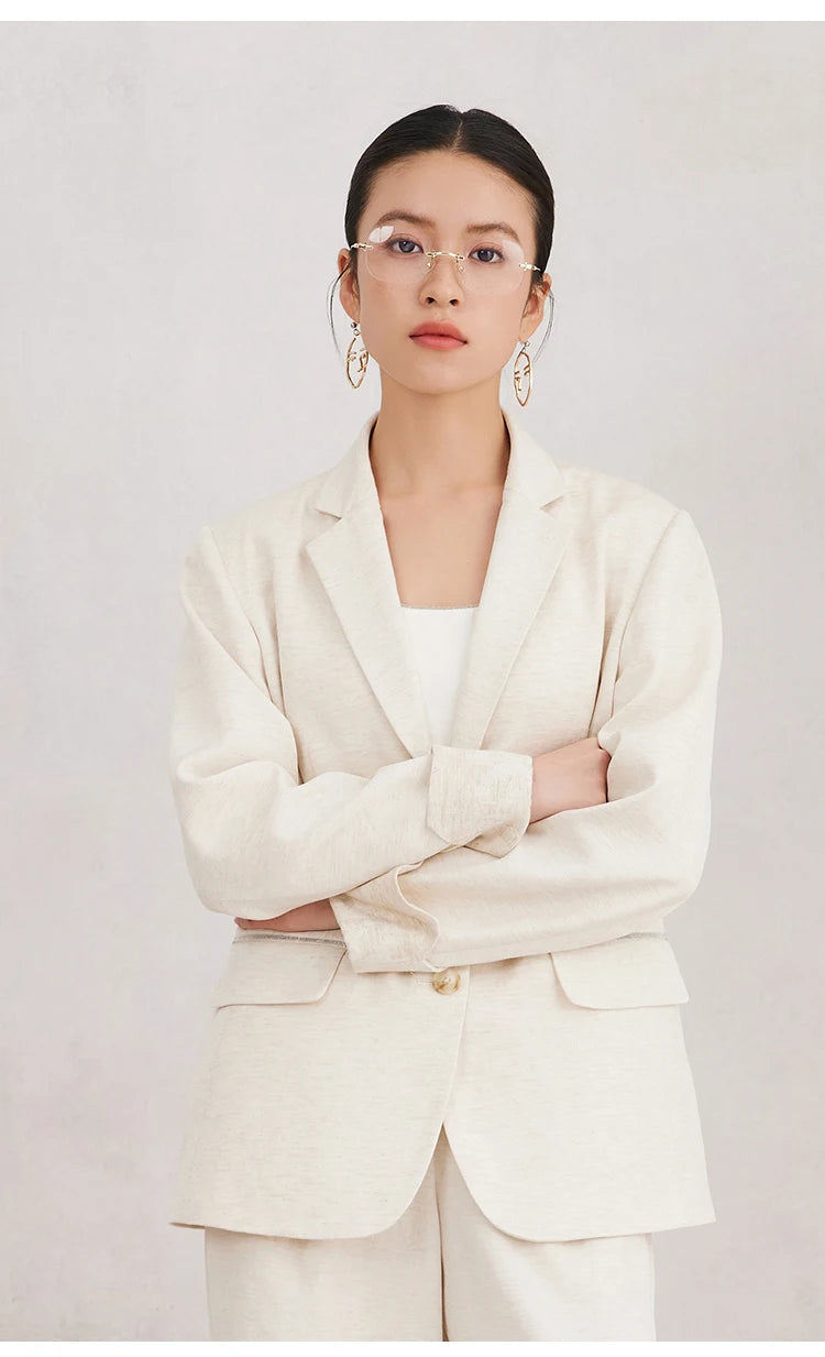 Women’s White Coffee blazer with arms crossed — highlighting the texture of the jacquard cuffs and the thoughtful balance between structure and ease. From Borcelleclothes.