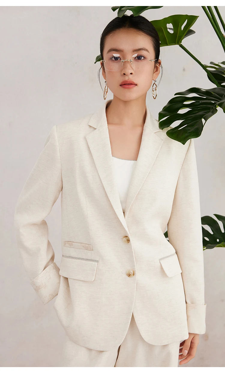 Back view of the Women’s White Coffee blazer with the model’s hand gently resting behind her — capturing the asymmetrical detailing and soft movement of the blazer. From Borcelleclothes.