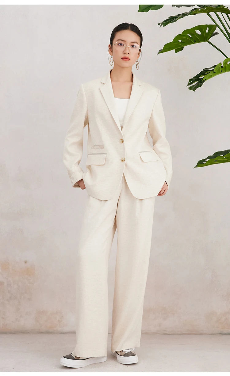 Women’s White Coffee blazer styled with hands tucked into pants pockets — showcasing the natural fall of the front panels and the quiet confidence of the look. From Borcelleclothes.