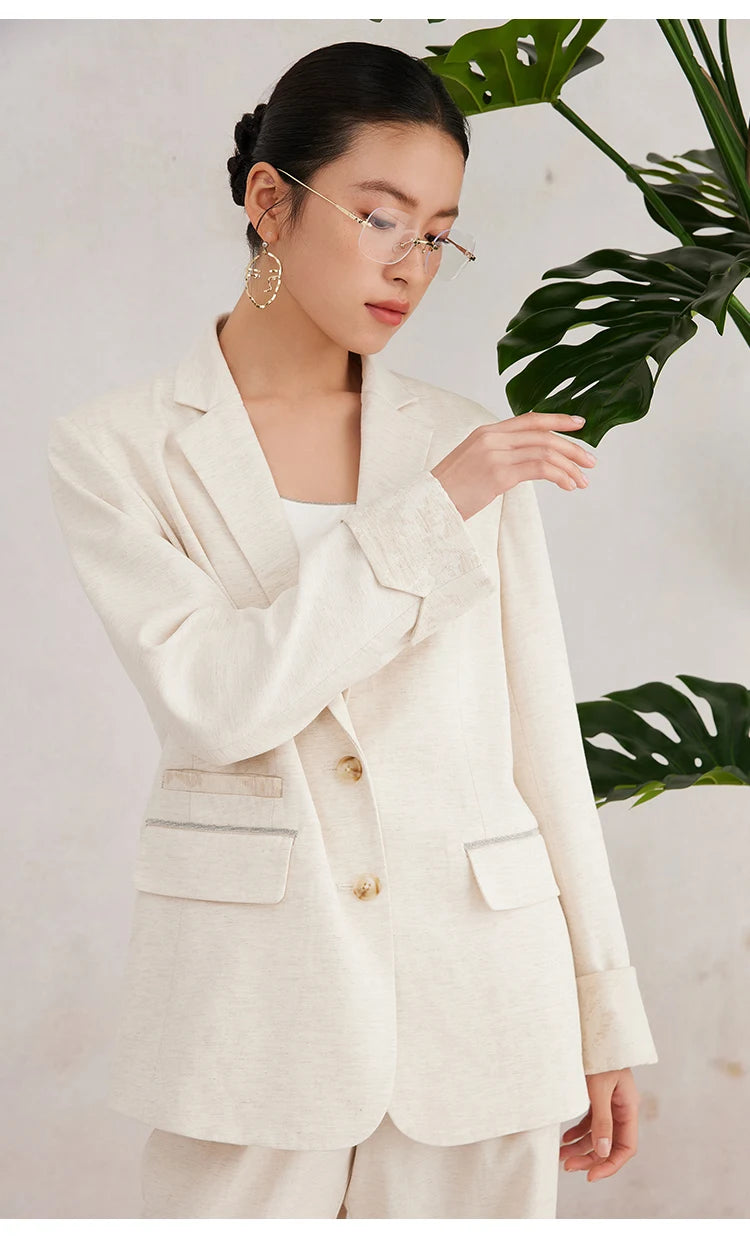 Women’s White Coffee blazer as the model lifts one arm — revealing the jacquard cuff in motion and how the linen blend fabric responds to light and gesture. From Borcelleclothes.