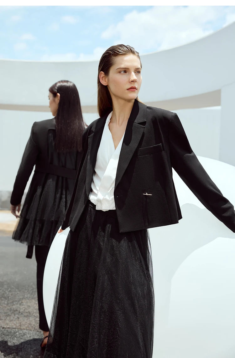 Women’s Wire Knot Detail Blazer in Onyx, model standing before a white sphere. From Borcelleclothes.