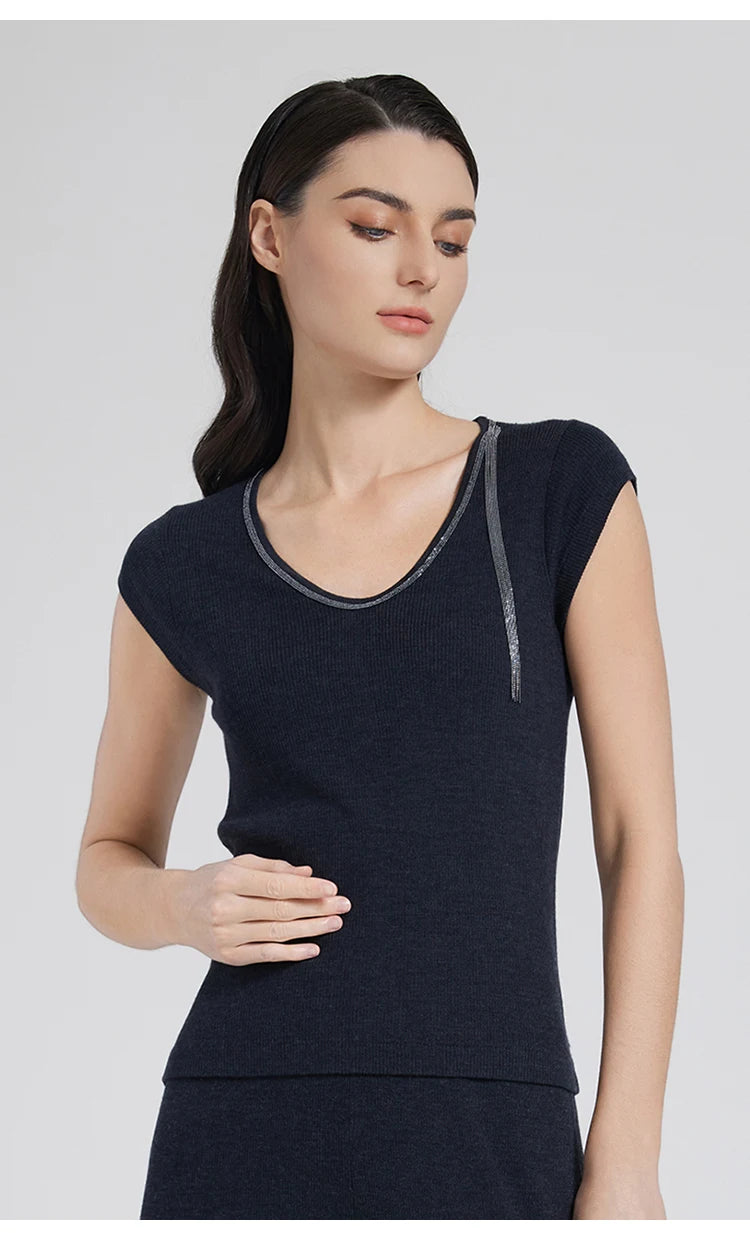 Model wearing women's wool-silk top in Black Pearl with rhinestone trim, gently touching her hip. From Borcelleclothes.