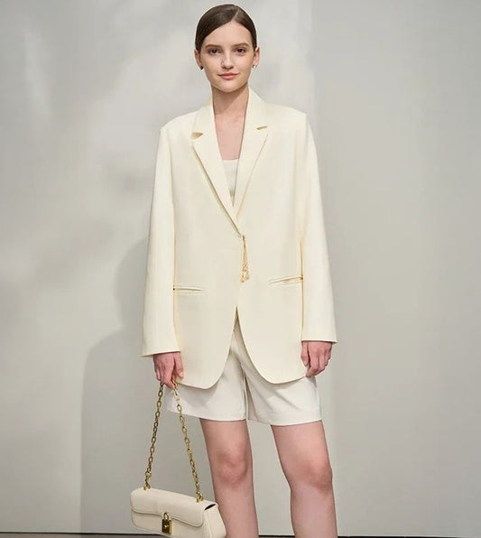 Women’s wrap blazer in Pearl Bush, with hidden hook-and-eye closure, notch lapels, welt pockets, golden pendant accent, and thigh-length cut – From Borcelleclothes.