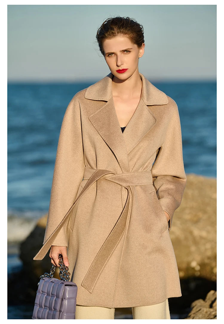 Model wearing a Cameo wrap cashmere coat, holding a handbag. From Borcelleclothes.