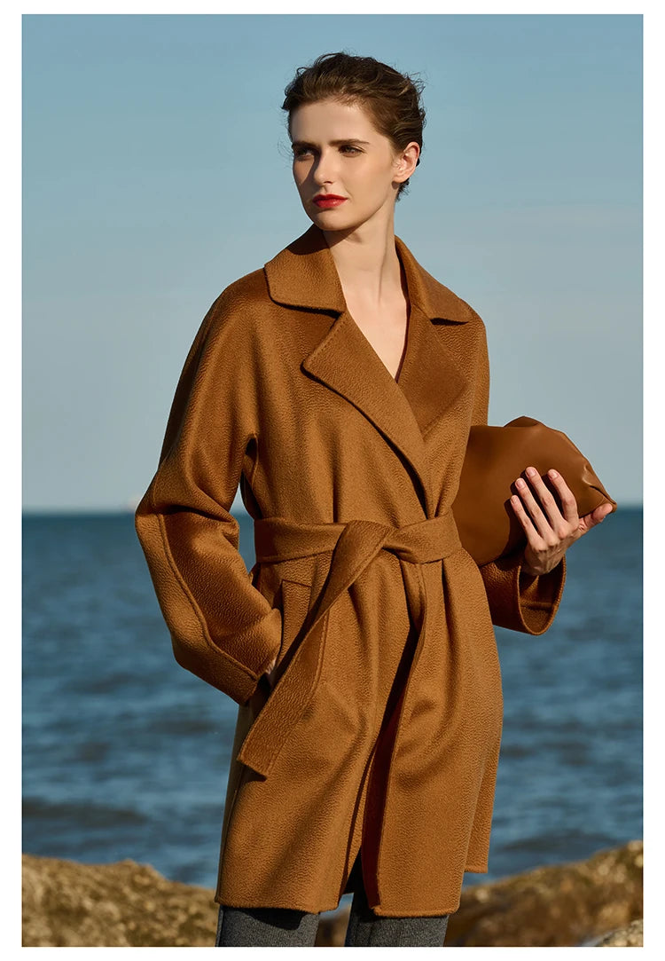 Model wearing a Rich Gold wrap cashmere coat, with one hand in pocket. From Borcelleclothes.
