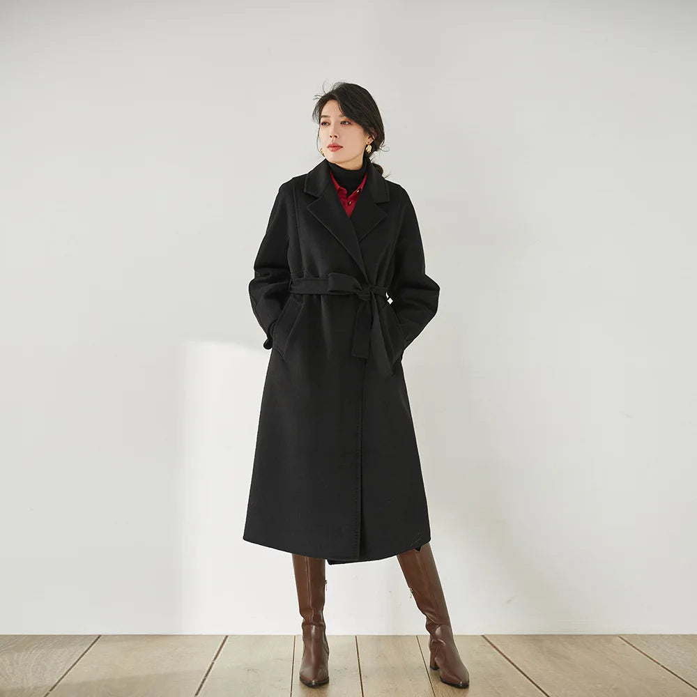 Women's Wrap Coat Redefined in Onyx—crafted from a luxurious blend of Merino wool and cashmere. Featuring square gussets for a structured silhouette, notch lapels, a single-welt pocket design, and an adjustable belt, this mid-calf wrap coat blends modern tailoring with timeless elegance. From Borcelleclothes.