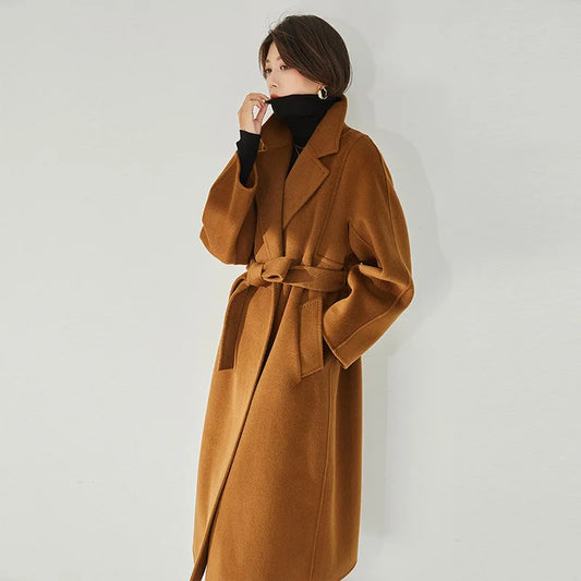 Women's Wrap Coat Redefined in Rich Gold—crafted from a luxurious blend of Merino wool and cashmere. Featuring square gussets for a structured silhouette, notch lapels, a single-welt pocket design, and an adjustable belt, this mid-calf wrap coat blends modern tailoring with timeless elegance. From Borcelleclothes.