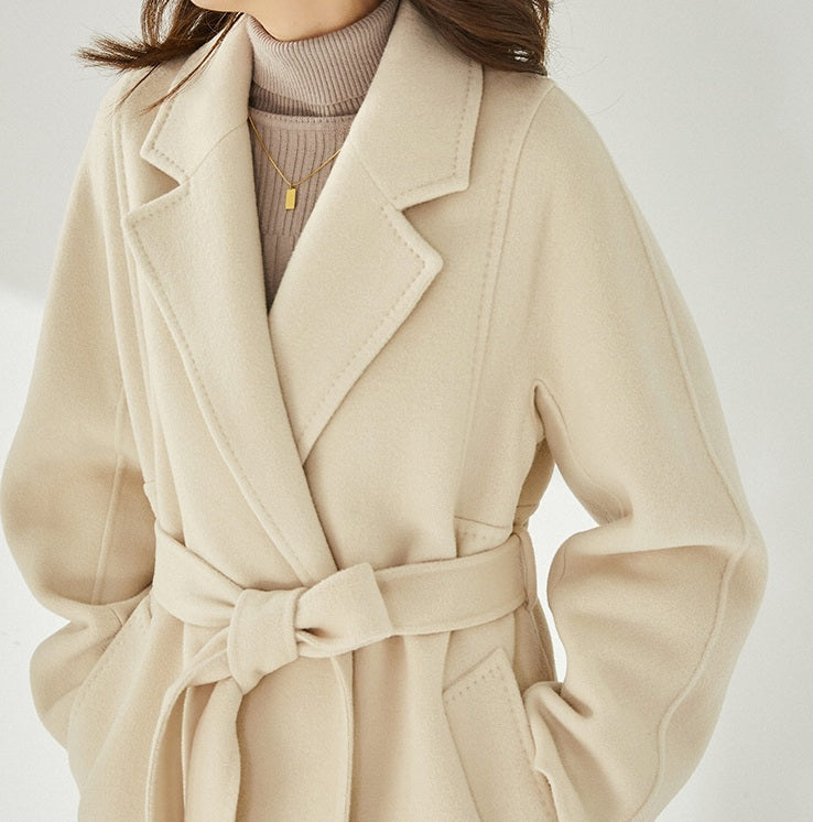 Mid-section view of the Women's Wrap Coat Redefined in Soft Amber, with hands in pockets, emphasizing its streamlined single-welt pocket design. From Borcelleclothes.