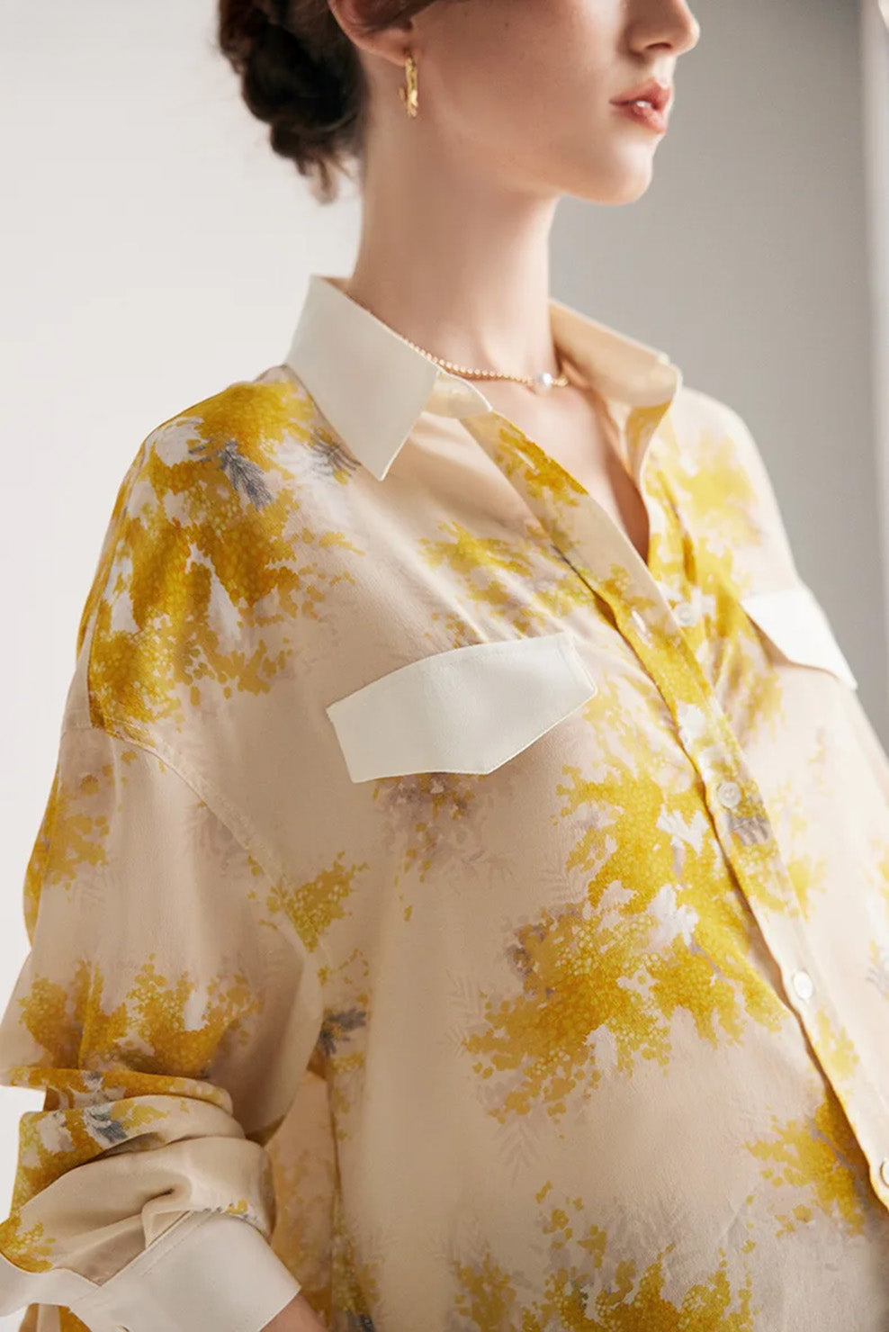 Upper part of a 100% Mulberry Silk Print Shirt featuring a dawn pink background with delicate yellow blooms, contrast collar, and bold accents. From Borcelleclothes.
