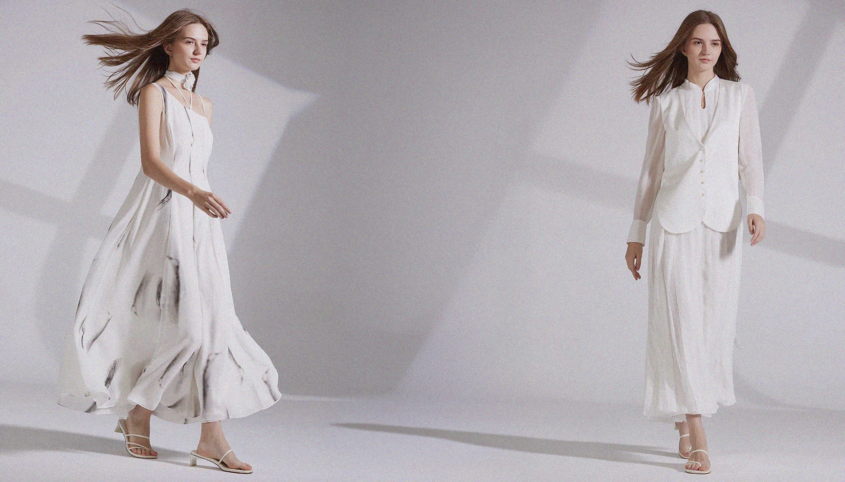 Banner image for Borcelle Summer '25 Collection featuring two women in flowing white outfits made of silk and structured fabrics, walking in soft light with dynamic hair movement.