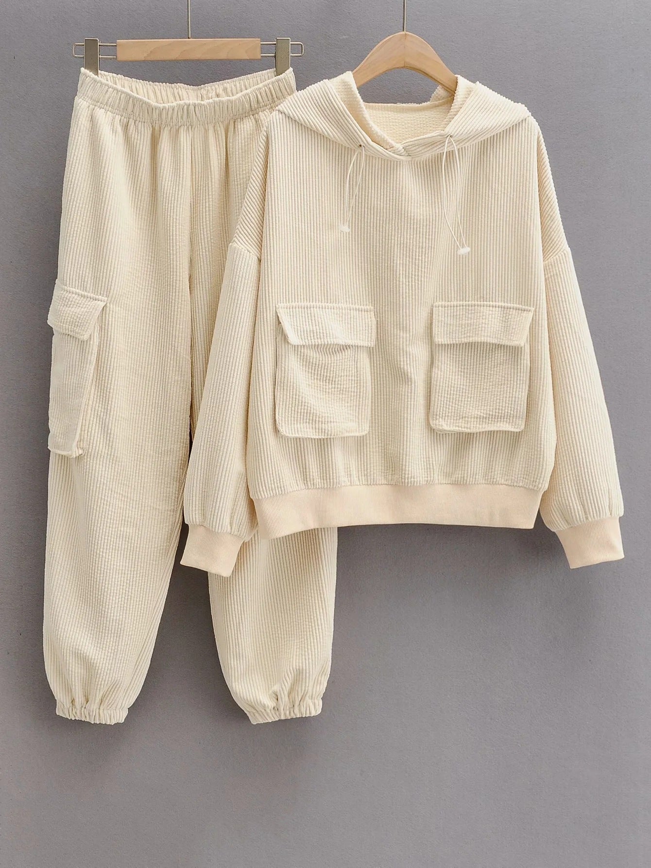 Women's Wide Wale Corduroy Sweatshirt and Sweatpants Set in Albescent White, designed with cargo flap pockets, a drawstring hood, and elastic ribbed cuffs and waistband for a relaxed, stylish fit. From Borcelleclothes.