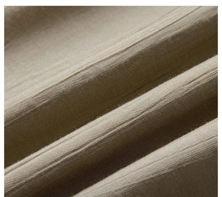 Folded Olive Haze fabric sample with visible crinkled texture and soft wave-like folds. From Borcelleclothes.