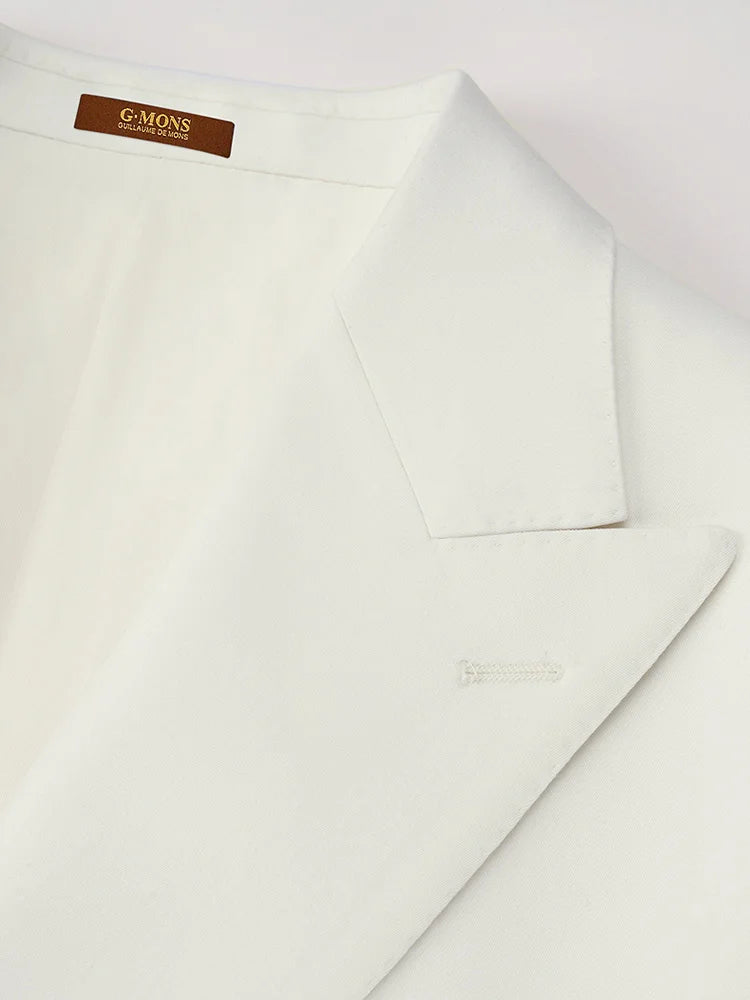 The Men's Alabaster Merino Wool Suit's blazer collar, showcasing the peaked lapels and precise tonal stitching. From Borcelleclothes.