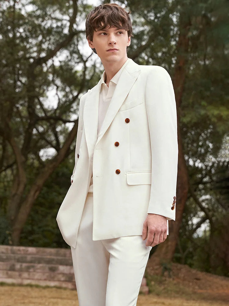 Model in the Men's Alabaster Merino Wool Suit turned slightly to the side, showcasing the blazer's structured silhouette and peaked lapels. From Borcelleclothes.