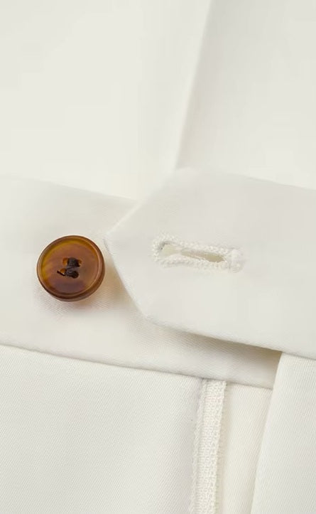 The Men's Alabaster Merino Wool Suit's pants button and buttonhole, showcasing the handmade tailoring. From Borcelleclothes.