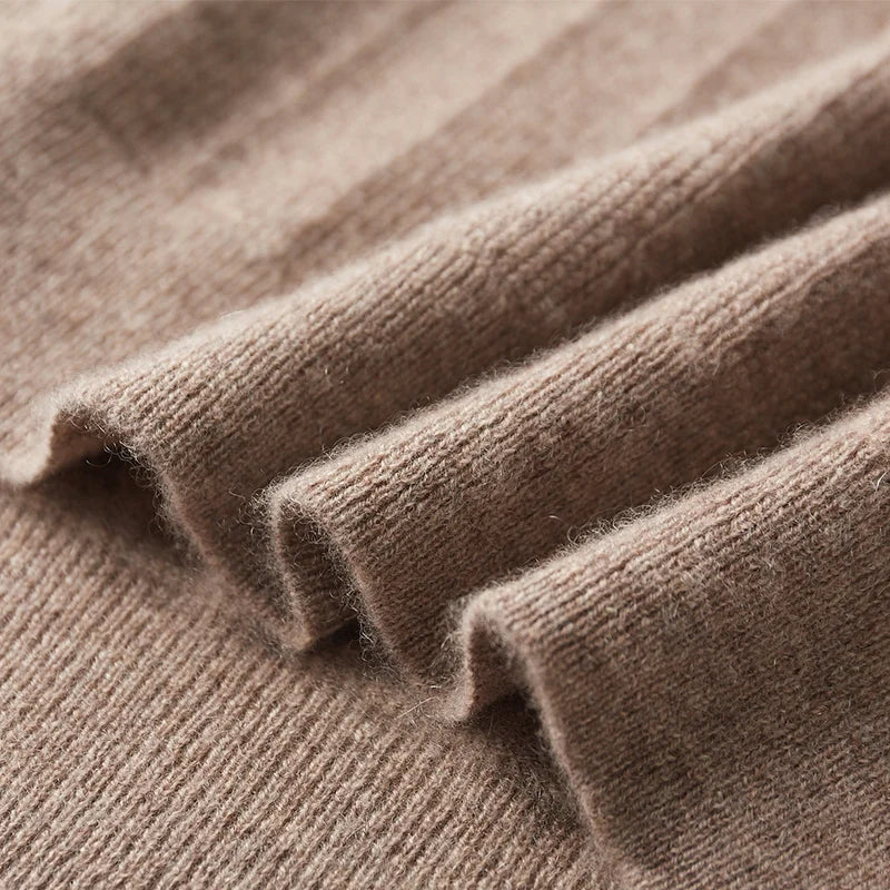 The ribbed bottom hem on the Men's Crossover V-Neck Cashmere Sweater in Sandrift, providing structure and a tailored look. From Borcelleclothes.