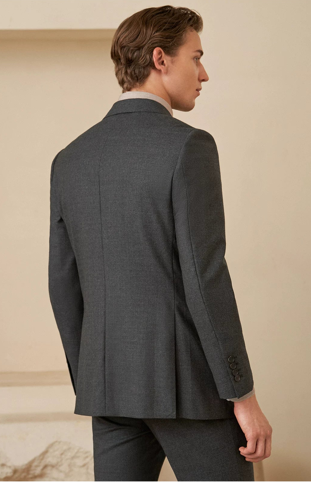 Rear view of the suit jacket displaying clean shoulder pitch, contoured waist fit, and double side vents — From Borcelleclothes.