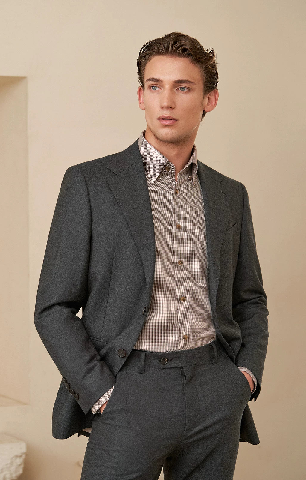 Close-up of a man wearing tailored wool trousers, resting his hands in the side pockets of flat-front flannel trousers — From Borcelleclothes.