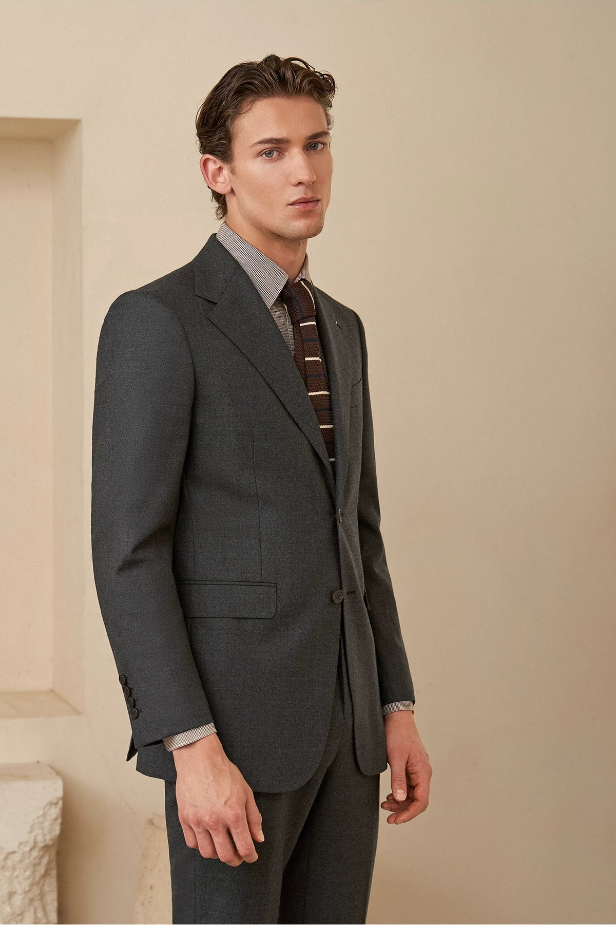 Semi-profile view highlighting the natural sleeve drape, chest canvas drape, and tailored trouser crease — From Borcelleclothes.
