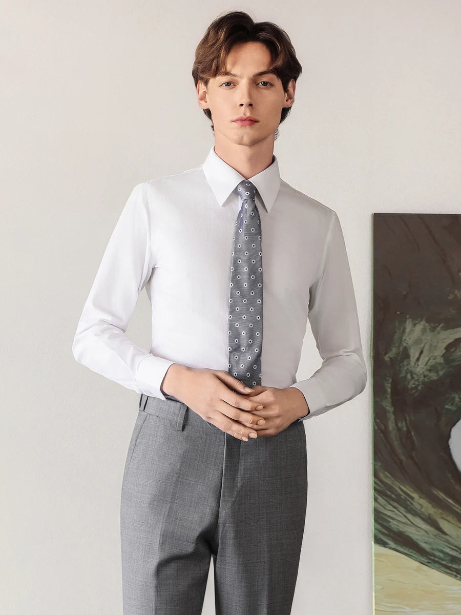 Confident man in a Lotus White cotton-silk shirt standing with touching hands, highlighting the elegant fit and noble texture of the luxury fabric. — From Borcelleclothes.