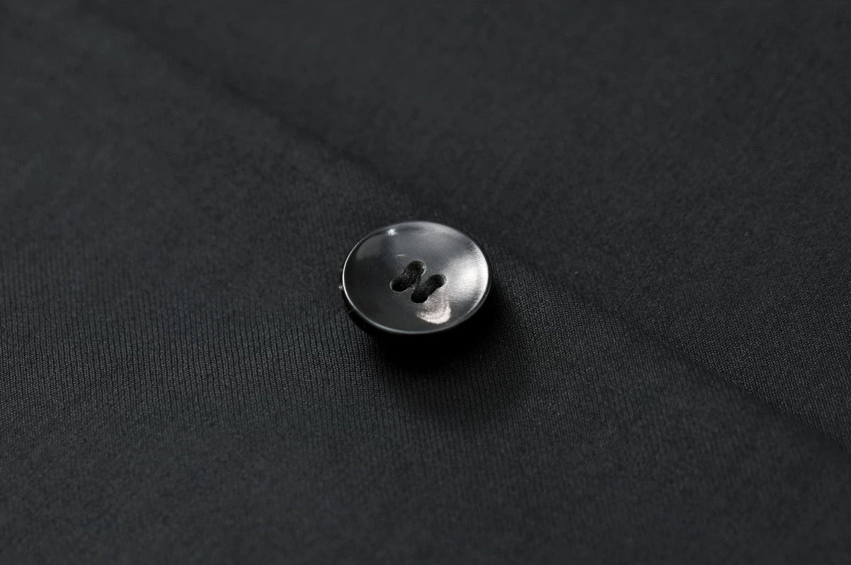 Detailed view of the premium horn button on the At the Abyss tailored wool jacket — From Borcelleclothes.