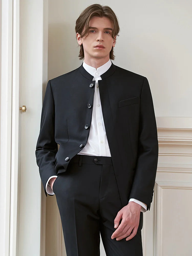 Model wearing the At the Abyss virgin merino wool suit with a stand collar, posing with hand in trousers pocket — From Borcelleclothes.
