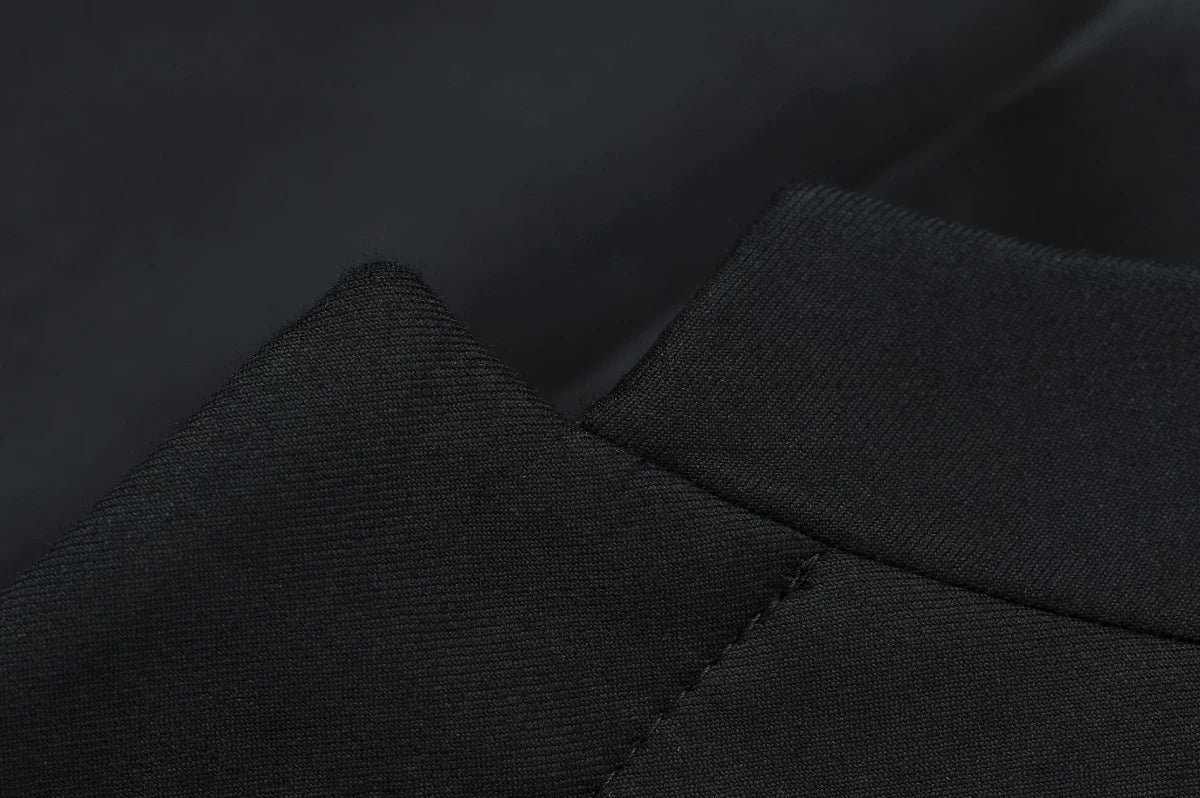 Macro view of the tailored notch transition between the minimalist stand collar and concealed front placket — From Borcelleclothes.