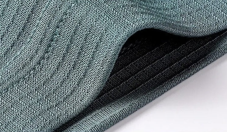 Close-up of the front right hem and side vent on the Bermuda Grey silk polo, displaying the horizontal micro-rib jacquard texture — From Borcelleclothes.
